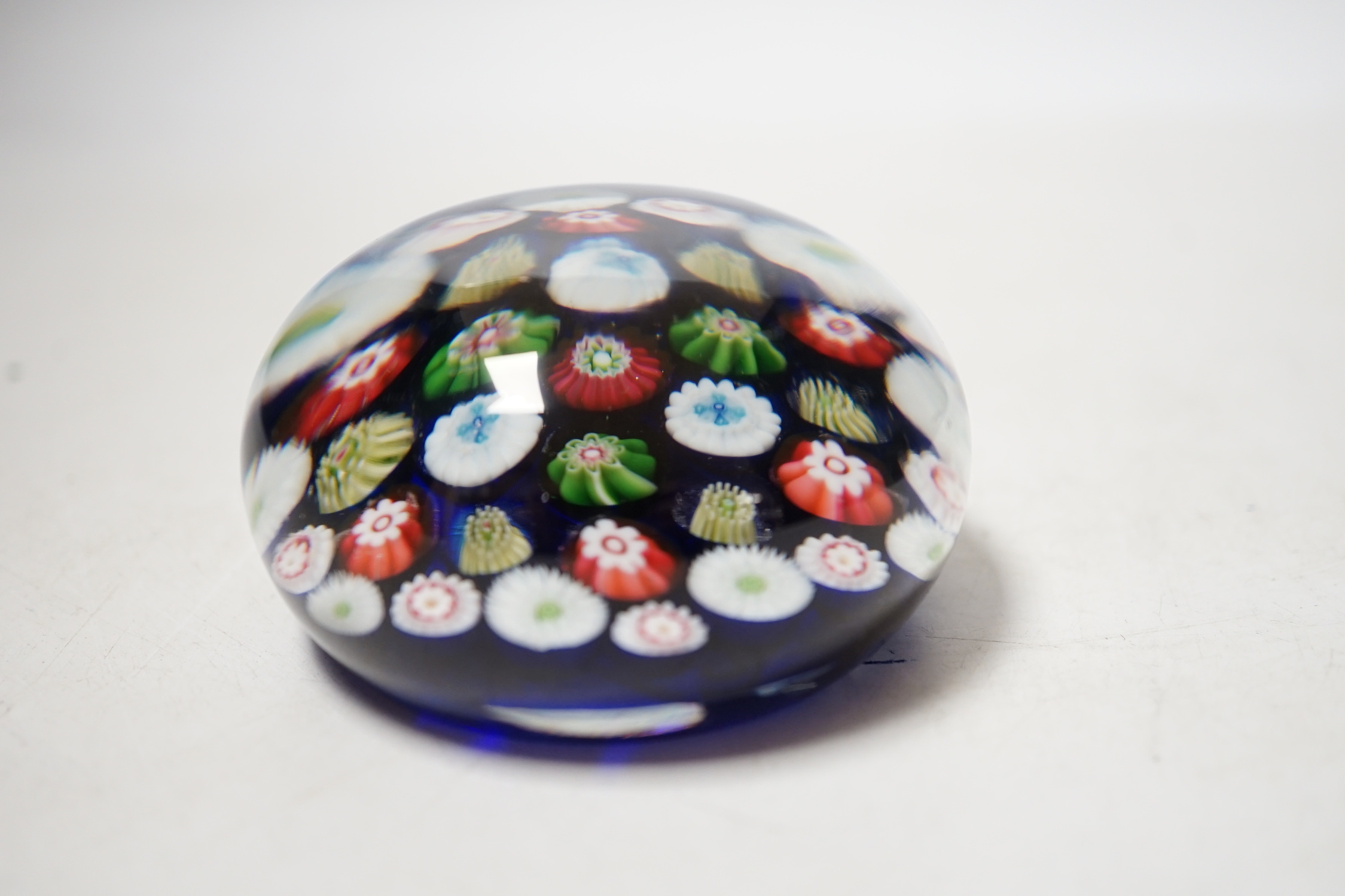 A Clichy translucent blue ground millefiori glass paperweight, 7cm in diameter